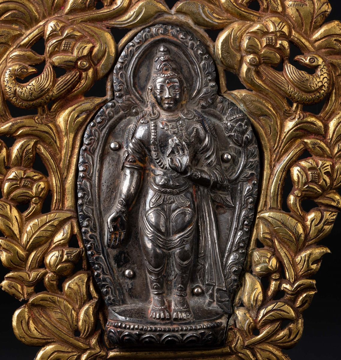 Placca in Argento e Bronzo Dorato con Figura di Buddha Stante Entro Aura Circondata da Motivi Veg...
