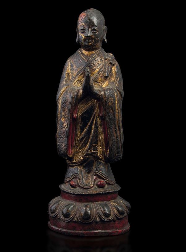 Figura di monaco in preghiera stante su fiore di loto in bronzo con tracce di doratura e policromia, Cina, Dinastia Ming (1368-1644)