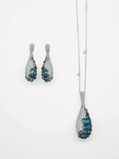 Modello Danae. Demi-parure Composta da un Paio di Orecchini ed un Pendente con Topazi Blu e Diama...