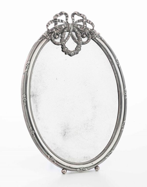 Specchio ovale con cornice in argento sormontata da fiocco. Italia, XX secolo