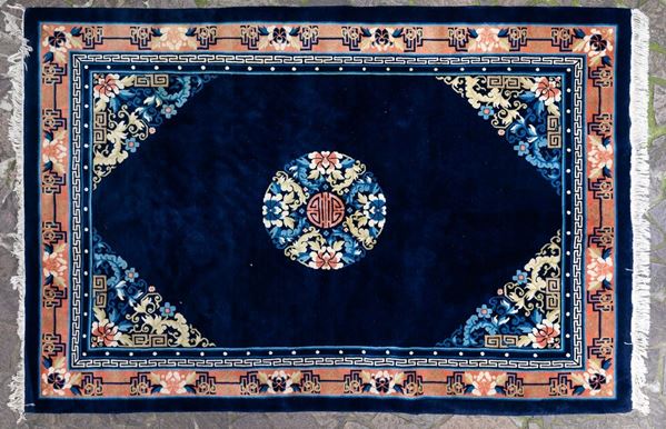 Tappeto con medaglione centrale e decori floreali su fondo blu, Cina, XX secolo