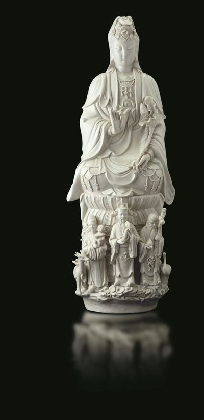 Gruppo in Porcellana Blanc De Chine Raffigurante Guanyin Seduta su Doppio Fiore di Loto e Tre Sag...