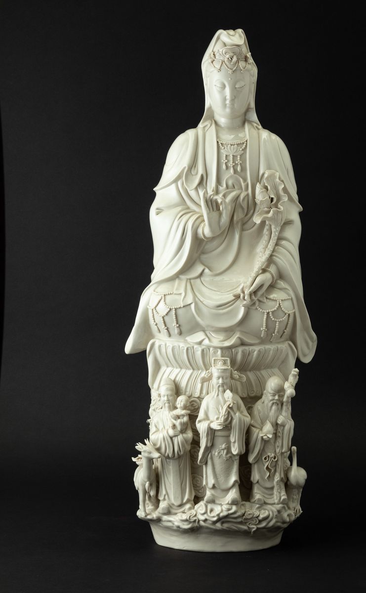 Gruppo in Porcellana Blanc De Chine Raffigurante Guanyin Seduta su Doppio Fiore di Loto e Tre Sag...