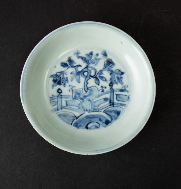 Piatto in porcellana bianca e blu con paesaggio centrale e decori vegetali, Cina, Dinastia Ming, XVII secolo