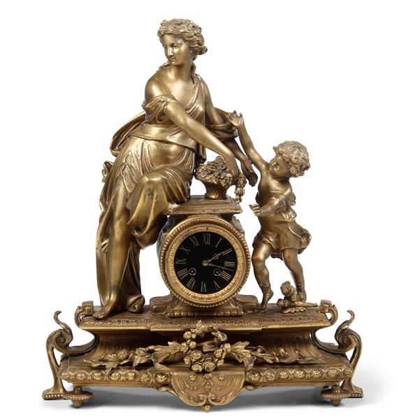 Orologio in bronzo dorato sormontato da scena allegorica. Francia, XIX secolo