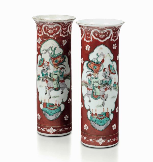 Coppia di vasi cilindrici in porcellana a fondo rosso. Cina XIX-XX secolo