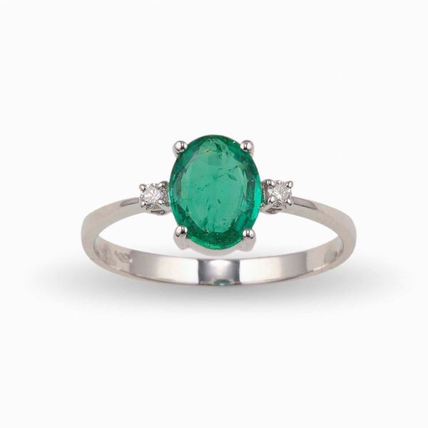 Anello con smeraldo ovale di ct 0.88 circa e due piccoli diamanti