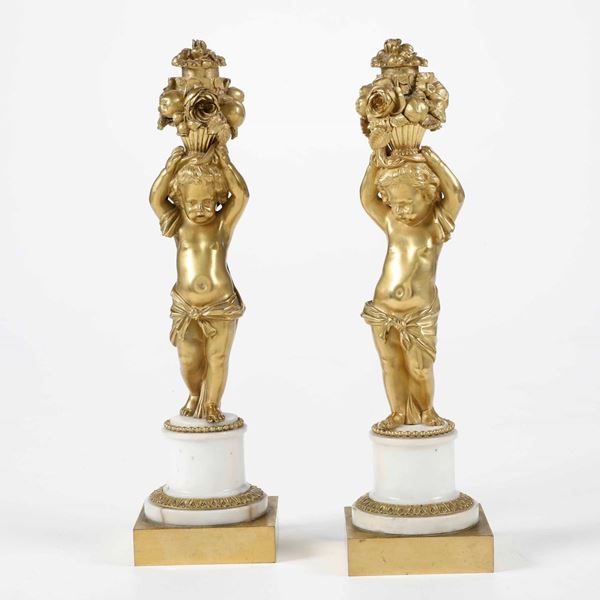 Coppia di putti in bronzo dorato su basette in marmo bianco. XIX-XX secolo