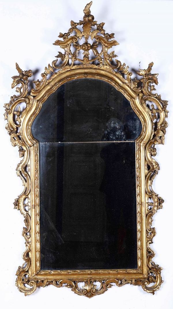 Specchiera in legno intagliato e dorato, cimasa e fregi traforati. XVIII-XIX secolo