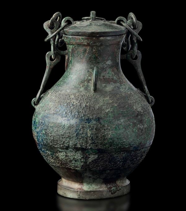 Raro e magnifico vaso Hu in bronzo con coperchio, manici a catena e decori geometrici a rilievo, Cina,  [..]