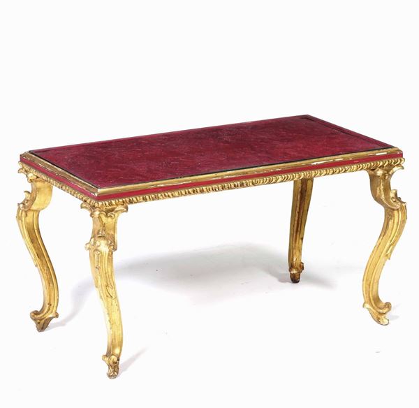 Tavolino in legno intagliato e dorato con piano in lacca rossa. XIX secolo