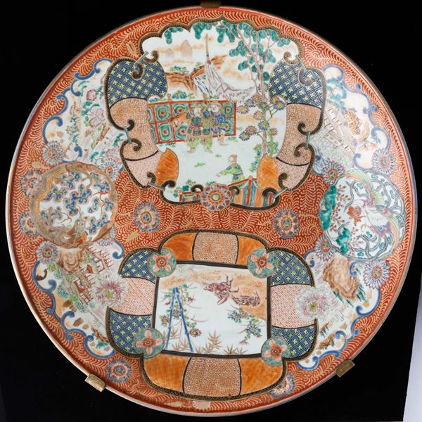 Grande piatto in porcellana Imari con figure di guerrieri e soggetti naturalistici entro riserve sagomate, Giappone, XIX secolo
