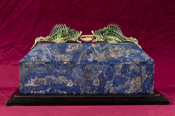 Rara scatola lastronata in lapislazzuli con decoro di pesci in argento e smalti policromi reggenti gemma  [..]