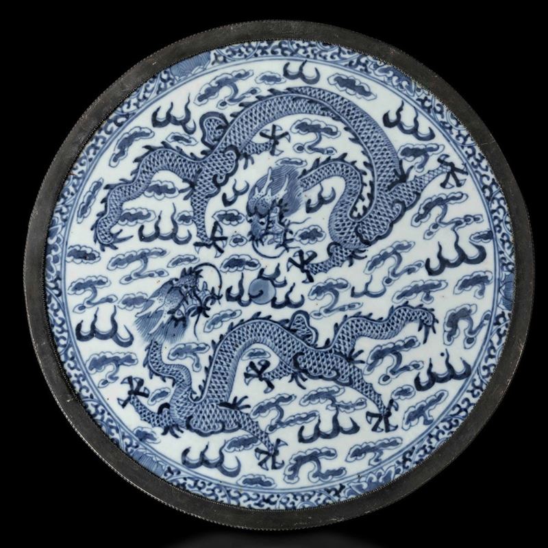 Placca circolare in porcellana bianca e blu con decoro di draghi tra le nuvole, Cina, Dinastia Qing, XIX secolo  - Asta Fine Chinese Works of Art - Cambi Casa d'Aste