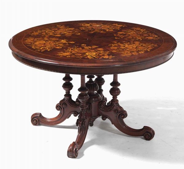 Tavolo in legno intagliato con piano lastronato ed intarsiato a motivi floreali in varie essenze. XIX-XX secolo