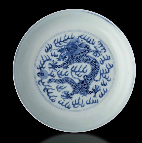 Piatto in porcellana bianca e blu con figura centrale di drago tra le nuvole, Cina, Dinastia Qing, marca e del periodo Guangxu (1875-1908)