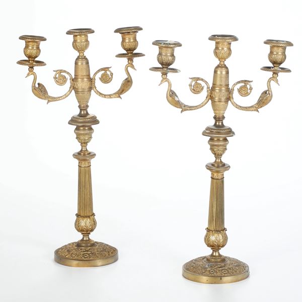 Coppia di candelabri a tre luci in bronzo dorato e cesellato. XIX-XX secolo