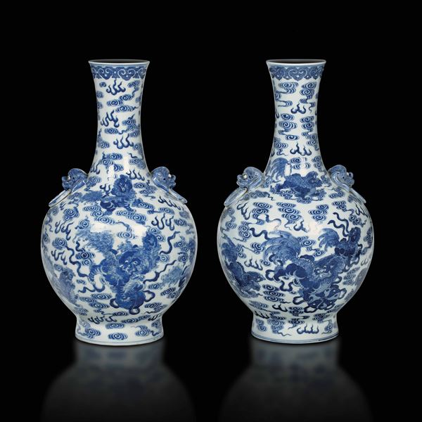 Coppia di vasi a bottiglia in porcellana bianca e blu con mascheroni e figure di cani di Pho, Cina, Dinastia Qing, epoca Guangxu (1875-1908)
