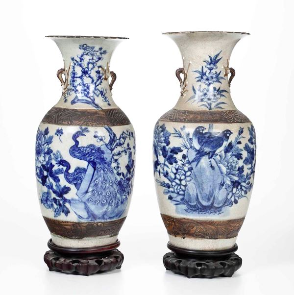 Coppia di vasi in porcellana con piccole anse e raffigurazioni di pavoni entro paesaggio sui toni del blu, Cina, Dinastia Qing, XIX secolo