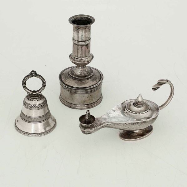 Lotto composto da una lampada ad olio, un portacandela e una campanella in argento