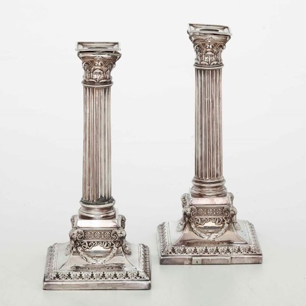 Coppia di candelieri in argento fuso, sbalzato e cesellato. Inghilterra XX secolo, probabilmente Londra; marchi consunti di difficile lettura