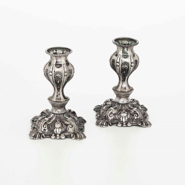Coppia di piccoli candelieri in argento fuso e sbalzato. Argenteria italiana del XX secolo (apparentemente privi di punzonatura)
