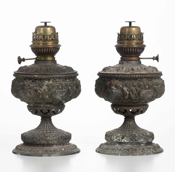Coppia di lumi a olio in metallo fuso e sbalzato. XIX secolo