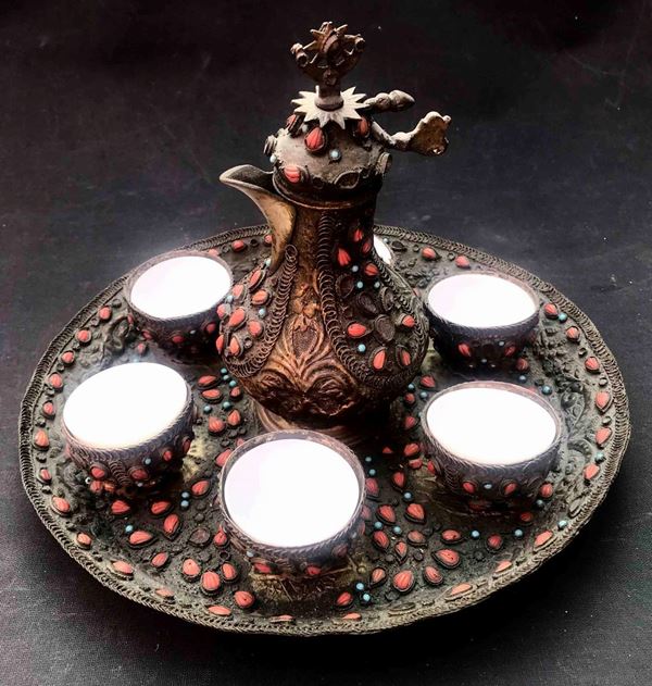 Servizio da caffè in metallo sbalzato e decorato con pietre rosse e azzurre. Arte orientale
