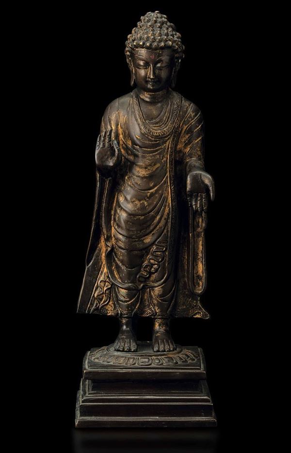 Figura di Buddha stante su fiore di loto in bronzo con tracce di doratura, Cina, Dinastia Qing, XVII secolo
