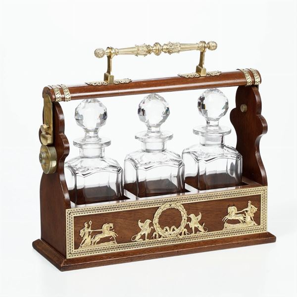 Set di tre bottiglie da liquore in vetro entro custodia in legno con finimenti in bronzo dorato e cesellato. XIX secolo