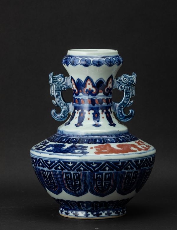 Vaso in porcellana con anse sagomate e decoro d’ispirazione arcaica nei toni del blu e del rosso ferro, Cina, Dinastia Qing, XIX secolo