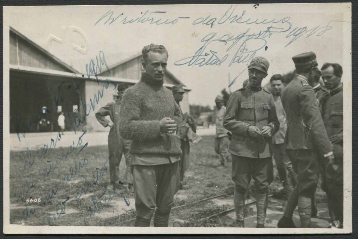 Cartolina fotografica di un gruppo di aviatori, con al centro il Capitano aviatore Natale Palli, 1918. Stima: 7.500-8000 €