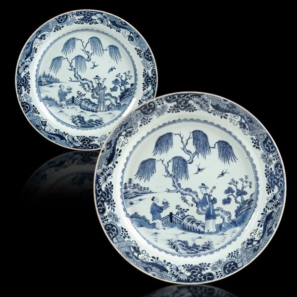 Coppia di piatti in porcellana bianca e blu con figura di saggio e fanciullo entro paesaggio, Cina, Dinastia Qing, epoca Qianlong (1736-1796)