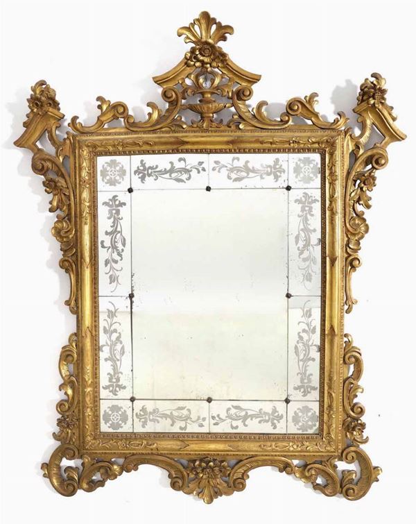 Specchiera con cornice in legno intagliato e dorato. XX secolo