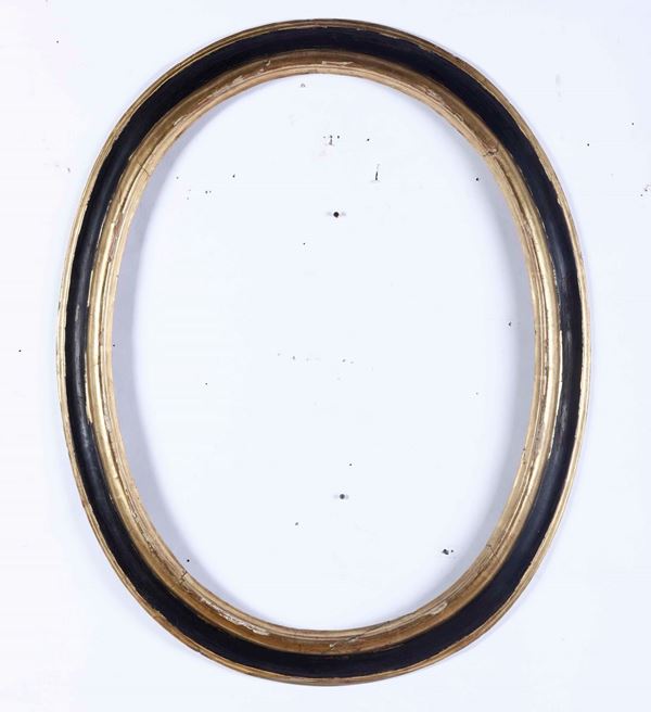 Cornice ovale in legno ebanizzato con profili dorati