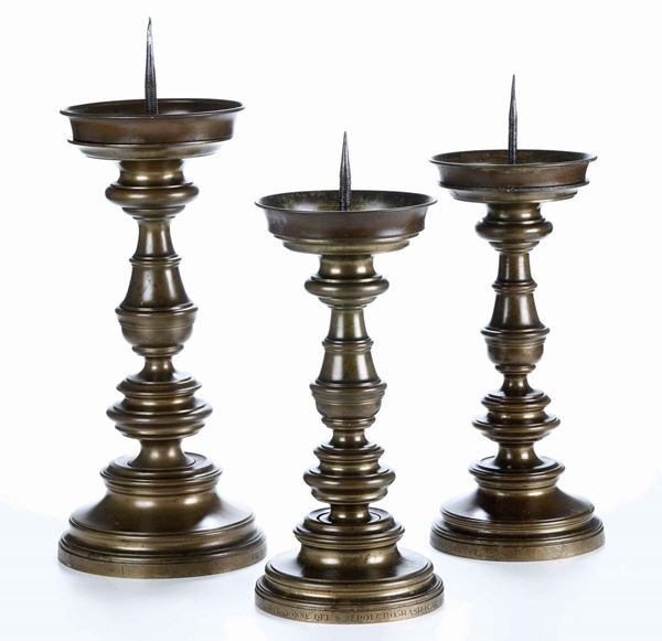 Lotto di tre candelieri in bronzo dorato in stile tardo gotico (datati 1934). Fonditore lombardo del XX secolo