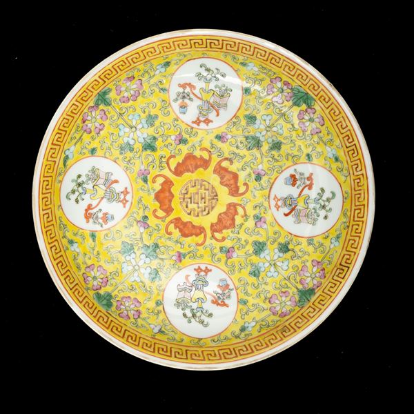 Piatto in porcellana con soggetti naturalistici entro riserva, decori floreali e pipistrelli su fondo giallo, Cina, Dinastia Qing, XIX secolo