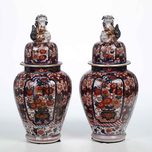 Coppia di potiche in porcellana Imari con decori floreali entro riserve e prese a foggia di cane di Pho, Cina, Dinastia Qiing, XIX secolo