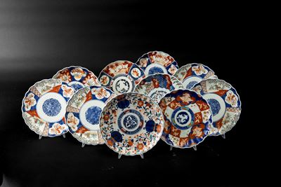 Giappone, lotto di dieci piatti in porcellana Imari con decorazioni floreali entro riserve, perio...