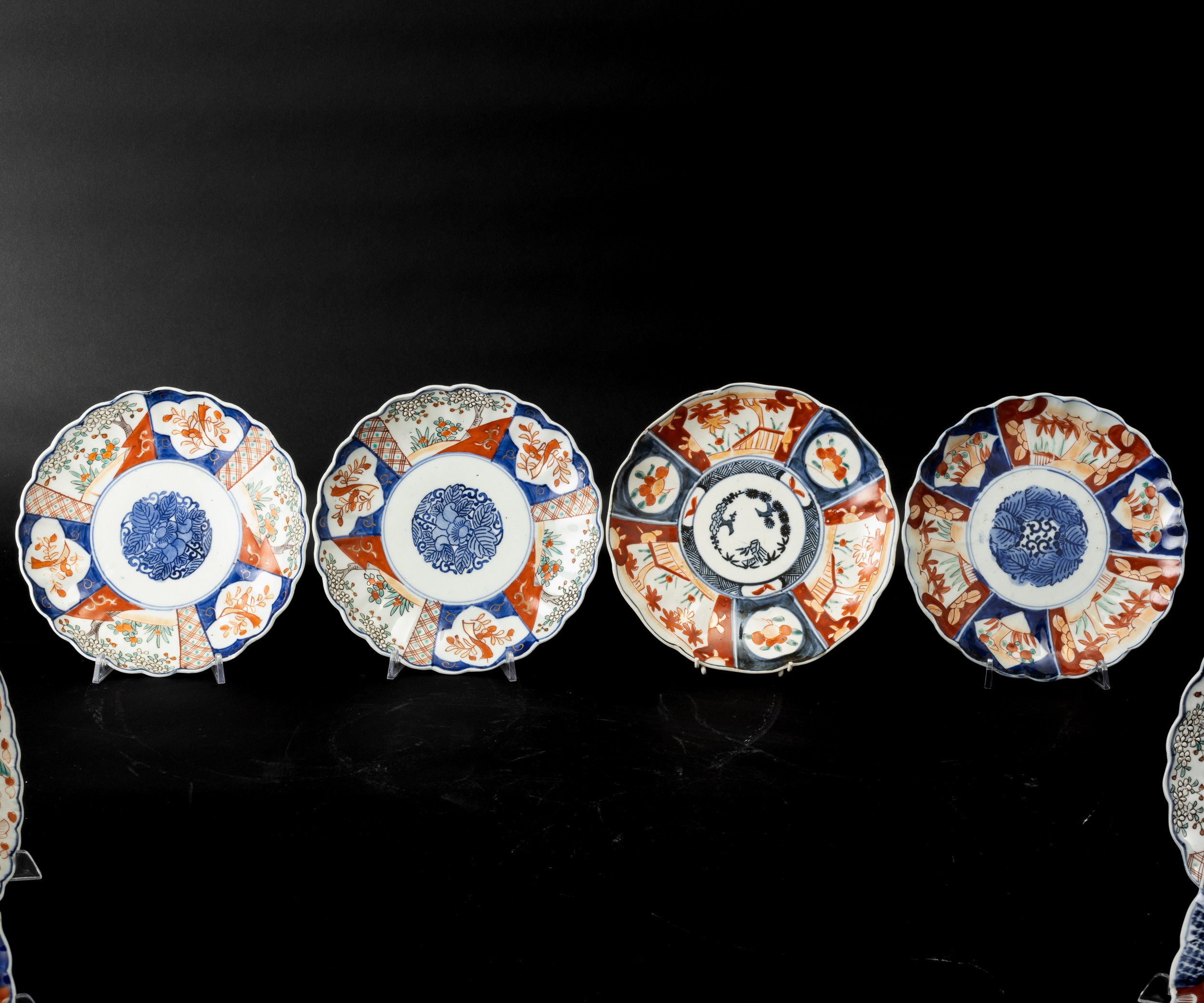 Giappone, lotto di dieci piatti in porcellana Imari con decorazioni floreali entro riserve, perio...