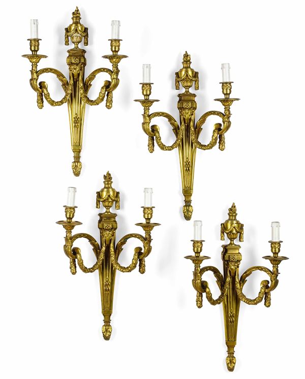 Quattro appliques a due luci in bronzo dorato. XIX-XX secolo