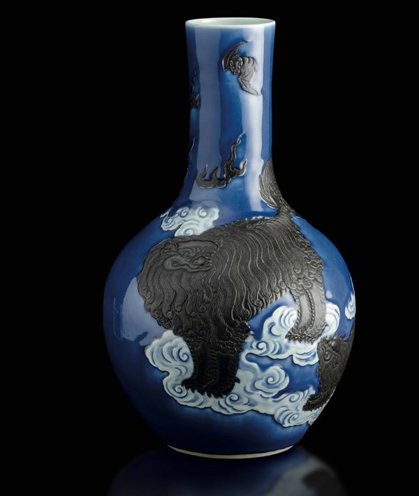 Raro vaso a bottiglia in porcellana con figura di cane di Pho a rilievo su fondo blu, Cina, Dinastia Qing, XIX secolo