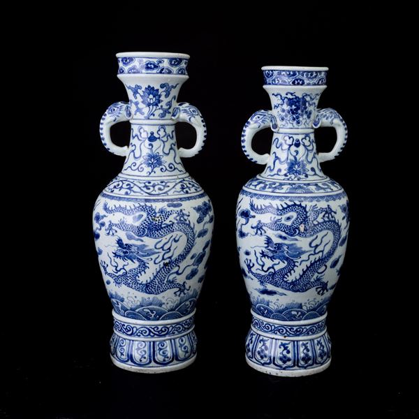 Coppia di vasi biansati in porcellana bianca e blu raffiguranti draghi a decoro floreale, Cina, Dinastia Qing, XIX secolo