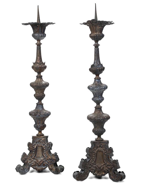 Coppia di candelieri in metallo sbalzato con struttura interna in legno. XVIII secolo