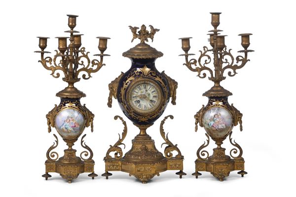 Trittico da camino composto da coppia di candelabri e un orologio in porcellana di Sevres e bronzo dorato.  [..]