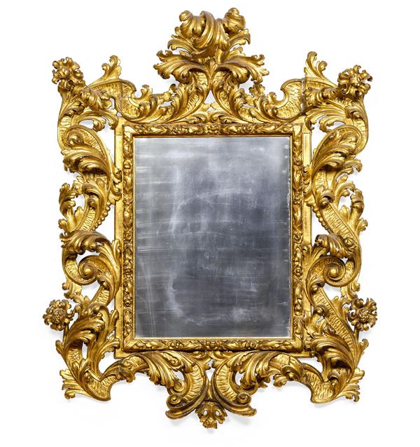 Specchiera barocca in legno riccamente intagliato e dorato. Centro Italia XVII-XVIII secolo