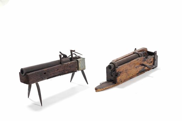 Due cannoni in metallo su supporto in legno