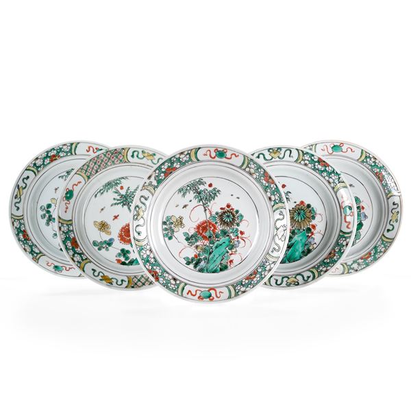 Cinque piatti in porcellana Famiglia Verde con decori floreali e soggetti naturalistici entro riserve, Cina, Dinastia Qing, epoca Kangxi (1662-1722)