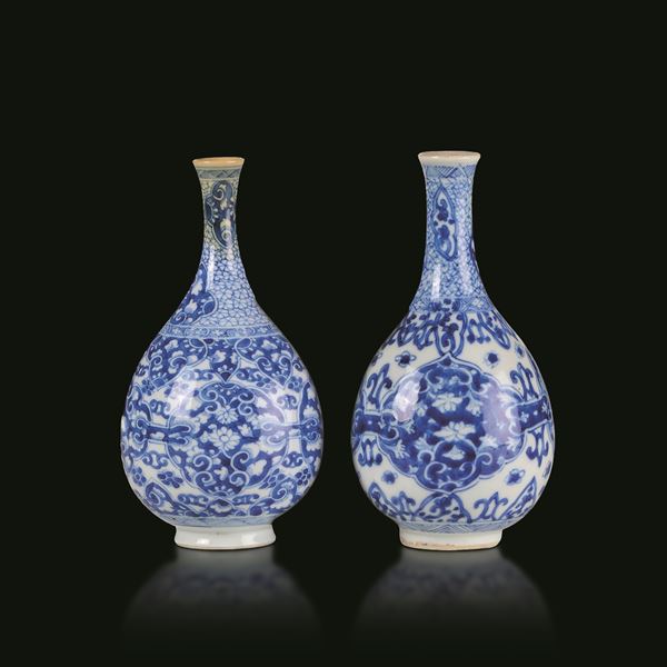 Coppia di vasi a bottiglia in porcellana bianca e blu con decori floreali entro riserve sagomate, Cina, Dinastia Qing, epoca Kangxi (1662-1722)