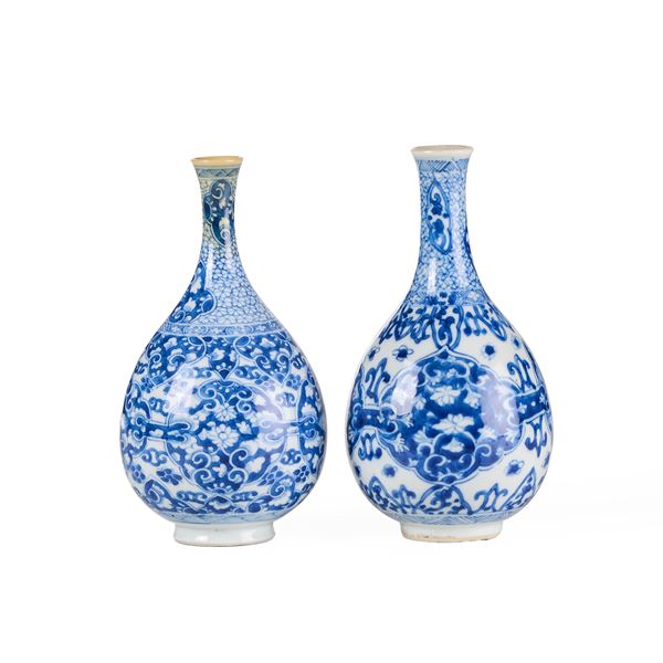 Due vasi a bottiglia in porcellana bianca e blu con decori floreali entro riserve sagomate, Cina, Dinastia Qing, epoca Kangxi (1662-1722)